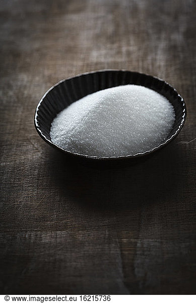 Bowl of sugar on table  close up