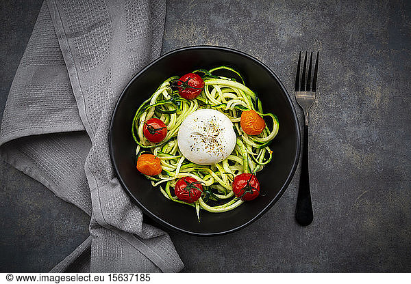 Bowl of zoodles with baked tomatoes and burrata cheese