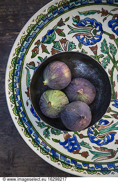 Bowl with four figs (Ficus carica) on traditional Andalusian ceramic plate  studio shot