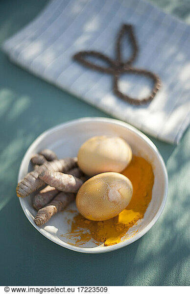Bowl with turmeric roots  turmeric powder and unpainted Easter eggs