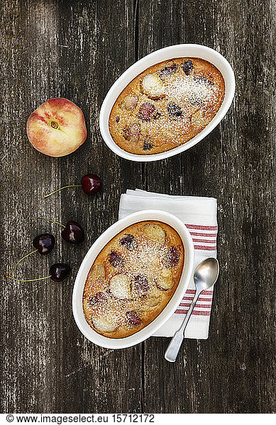 Bowls of gluten free homemade clafoutis with cherries  peaches and almonds