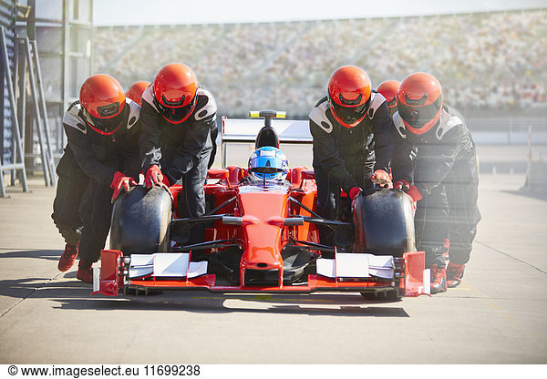 Boxencrew schiebt Formel-1-Rennwagen aus der Boxengasse