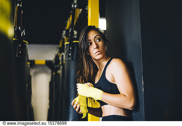Boxerin bandagiert ihre Hände in einer Turnhalle