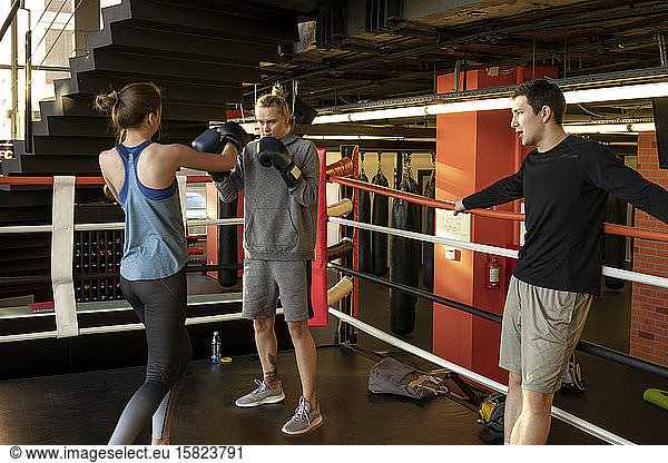 Boxerinnen kämpfen in Turnhalle unter Aufsicht des Trainers
