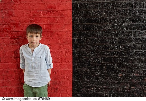 Boy against red and black wall