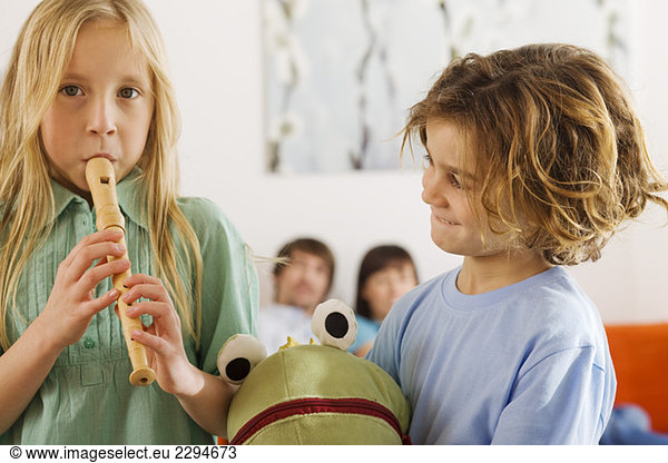 Boy (6-7) and girl (8-9)  playing recorder  portrait