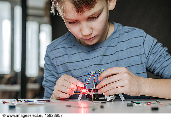 Boy assembling robot at home