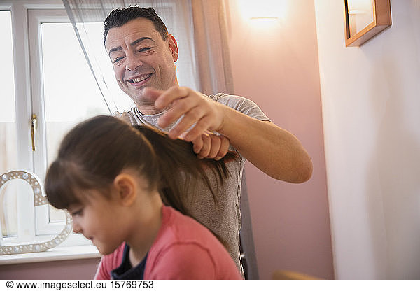 Boy brushing hair of daughter in bathroom