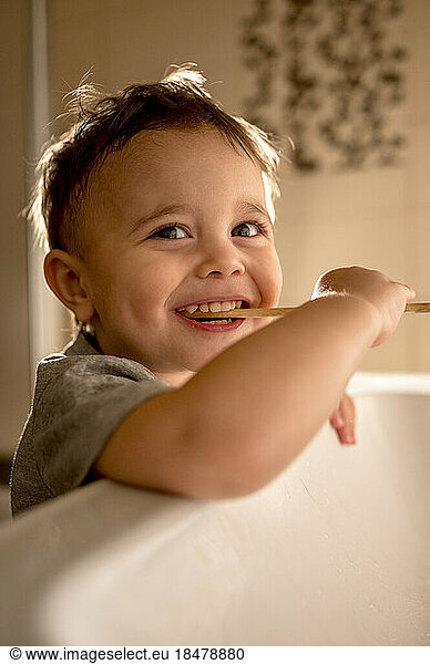 Boy brushing teeth at sink in bathroom
