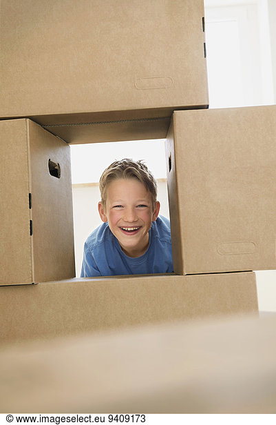 Boy building pile cardboard boxes moving house Boy building pile