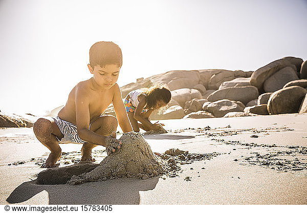 Boy buliding sand castle on the beach together