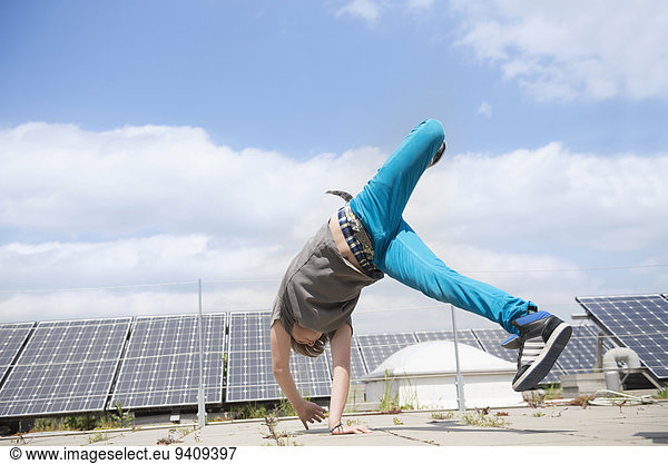 Boy cartwheel in front of solar park