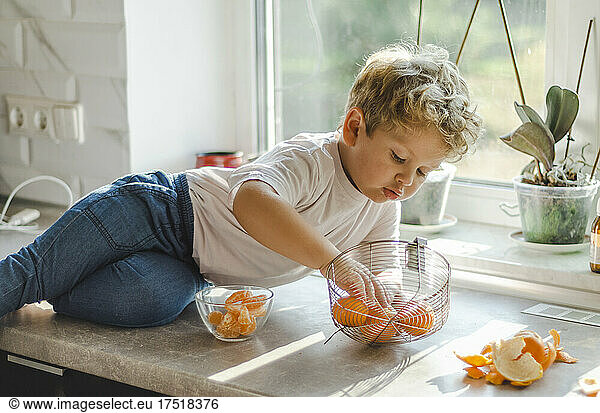boy chooses tangerine from basket