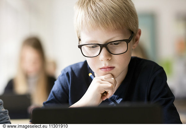 Boy concentrating on learning in classroom