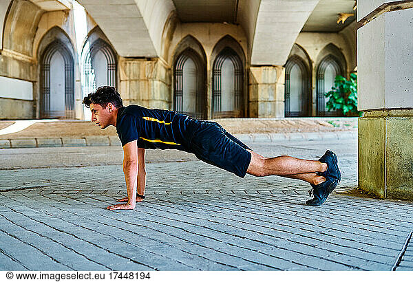 Boy doing stretching before running in the park