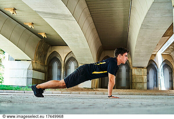 Boy doing stretching before running in the park
