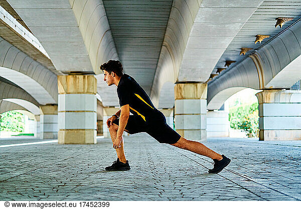 Boy doing stretching before running in the park