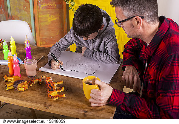 Boy drawing with his father.
