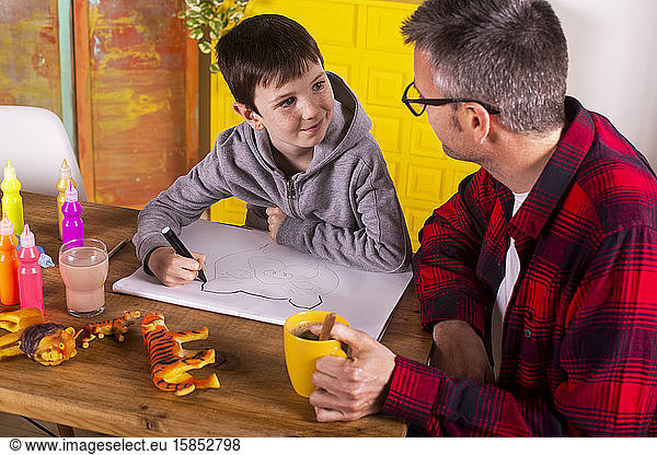 Boy drawing with his father.