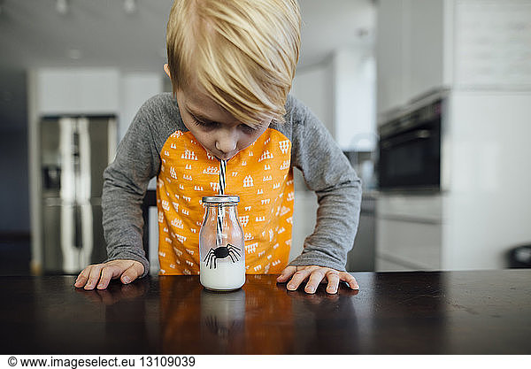 Boy drinking milk at table
