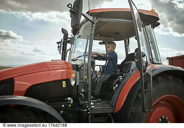 Boy driving tractor in field