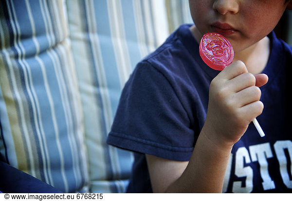 Boy eating a red lollipop  Otterburn  Quebec