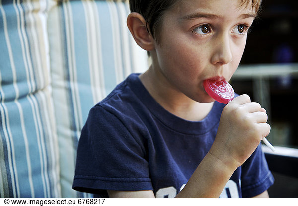 Boy eating a red lollipop  Otterburn  Quebec