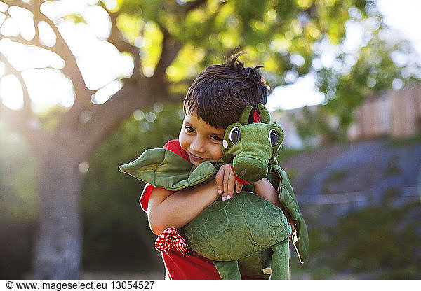 Boy embracing stuffed toy at park