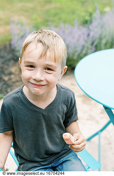 Boy enjoying his popsicle outside on the patio