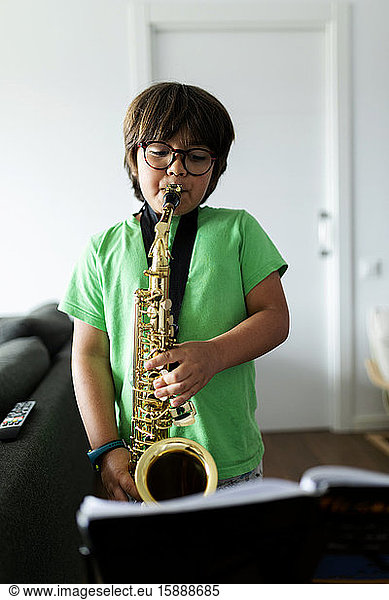 Boy exercising to play the saxophone at home