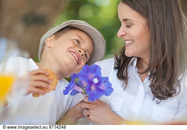 Boy giving flowers to mother