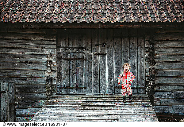 Boy going down wooden ramp in Scandinavian old house in winter