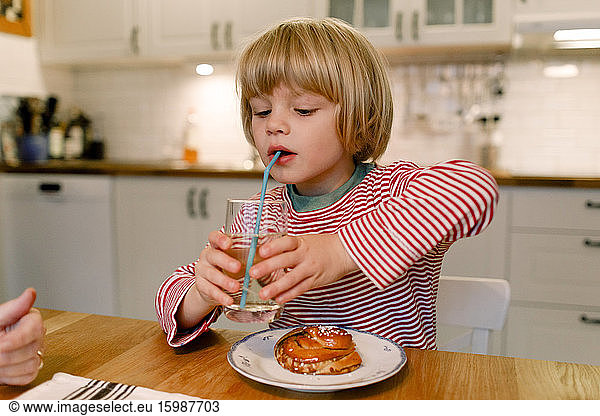 Boy having drink at dining table