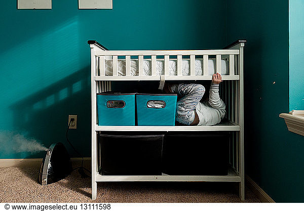 Boy hiding in bunkbed at home