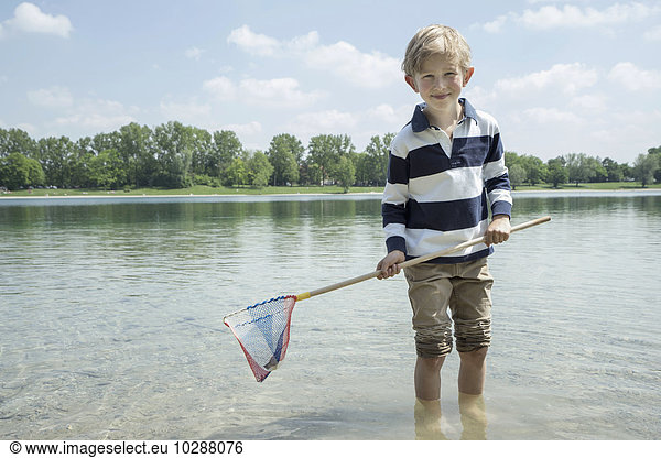 Boy holding brailer in the lake  Bavaria  Germany