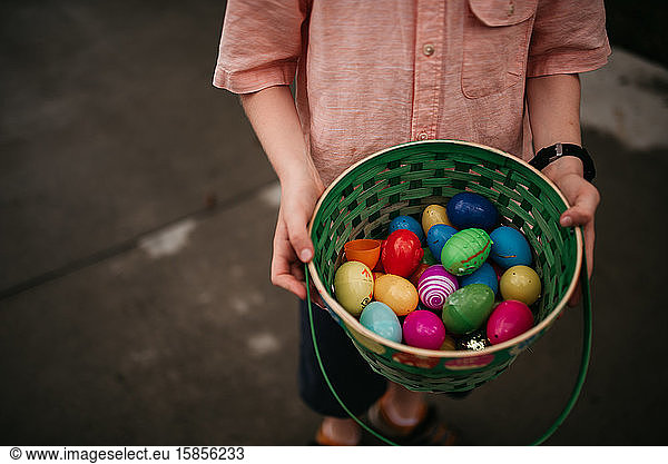 boy holding plastic eggs in basket