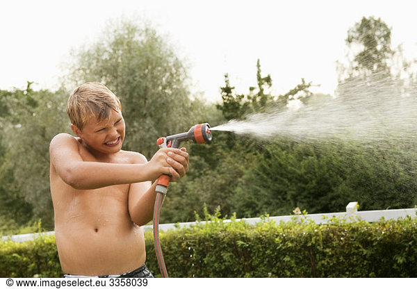 Boy holding water hose