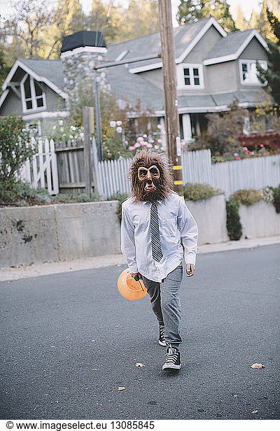 Boy in Halloween costume while walking on street