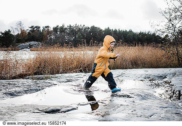 boy jumping and playing in the water on an island in Sweden