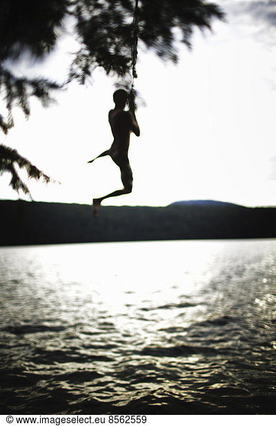 Boy jumping off rope swing