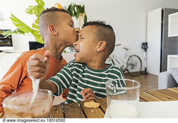 Boy kissing brother's forehead at home