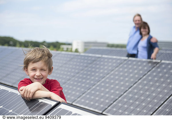 Boy leaning on solar panel photo-voltaic park