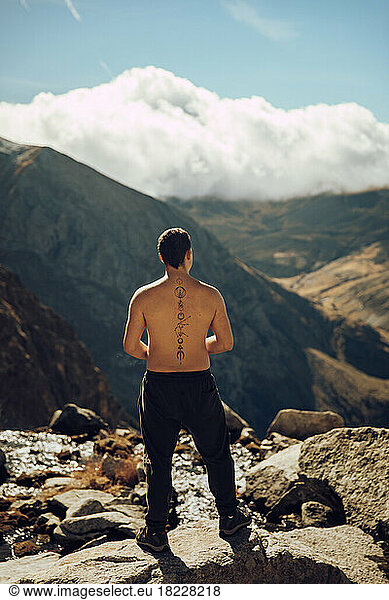 Boy looking at an impressive mountain landscape from the top