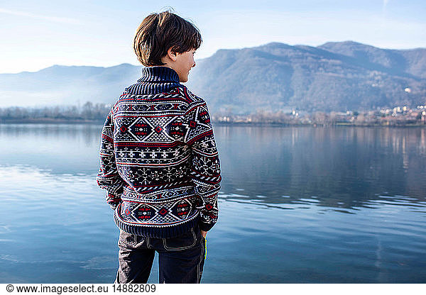 Boy looking out from lakeside  rear view  Lake Como  Lecco  Lombardy  Italy