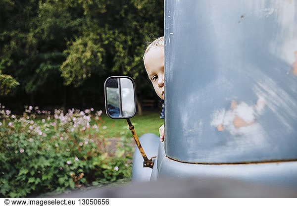 Boy looking through vintage car window