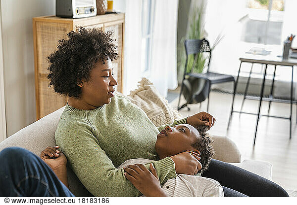 Boy lying on mother's lap at home