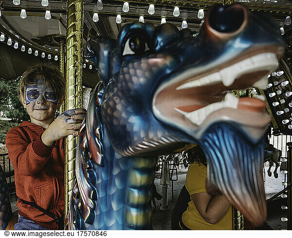 Boy on carousel with face paint