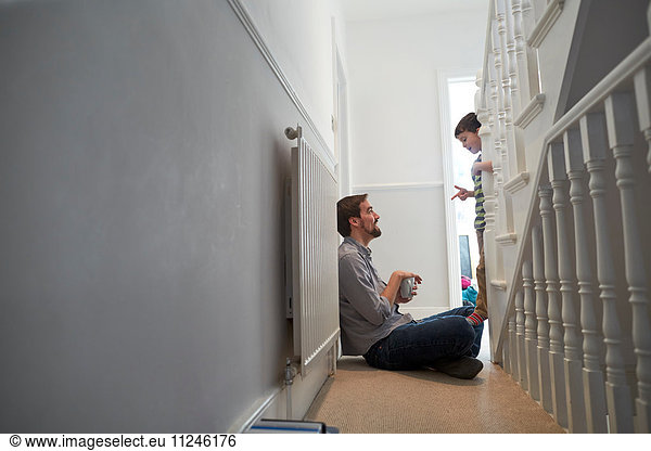 Boy on staircase talking and pointing to father