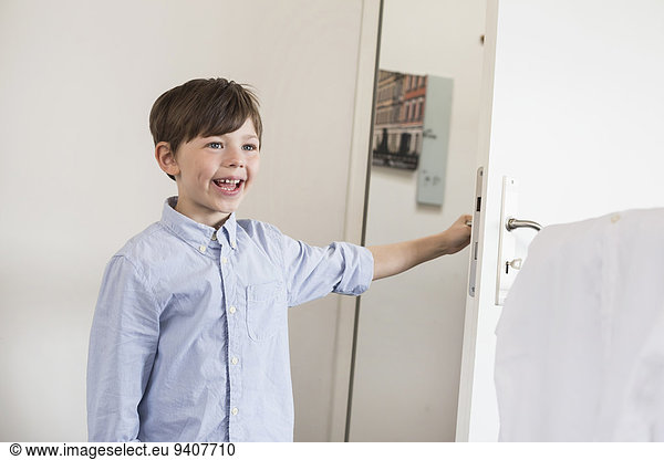 Boy opening door  smiling