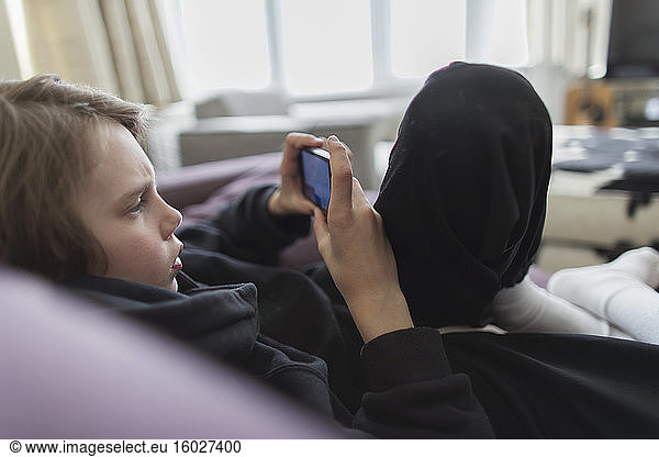 Boy playing video game with smart phone